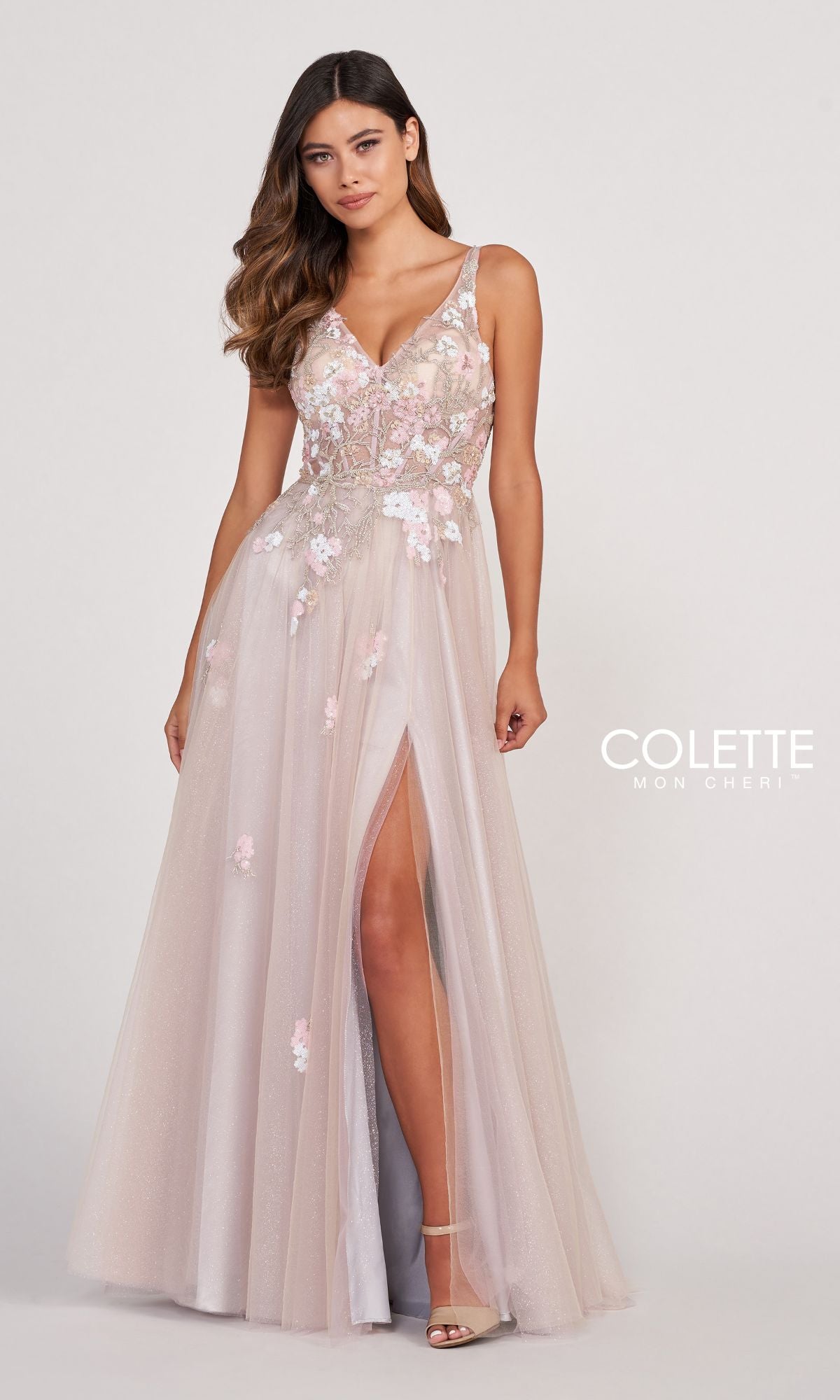 A woman wearing a Colette Corset-Back Silver Tulle Long Prom Dress stands against a plain background.